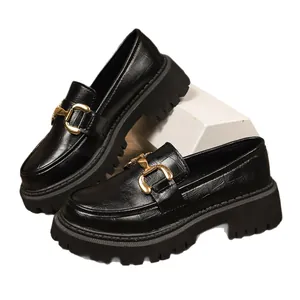 Women's black chunky platform loafers with gold buckle detail in British style.