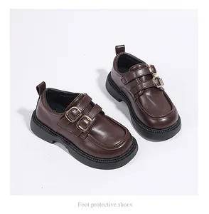 Macro detail of brown children's loafers featuring elegant double golden buckles