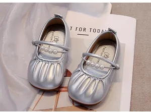 Vista detallada de zapatos de princesa plateados para niños con elegante tira de perlas