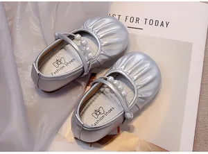 Vista detallada de zapatos de princesa plateados para niña con correa de perlas