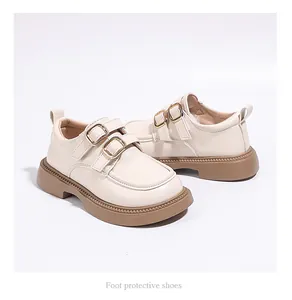 Detailed view of creamy white girls' princess loafers with double gold buckles.