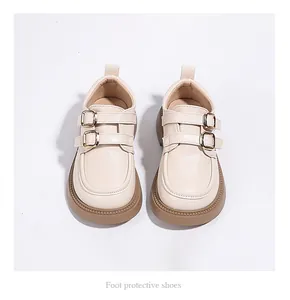Top-down view of elegant cream girls' loafers featuring stylish double gold buckle straps.