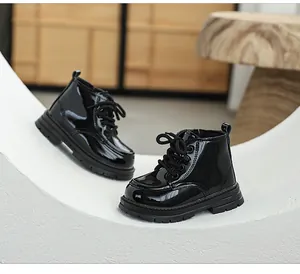 Detail view of black patent leather children's Martin boots with soft anti-slip soles