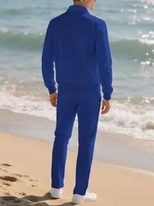 Back view of a men's blue textured casual tracksuit set standing on the beach