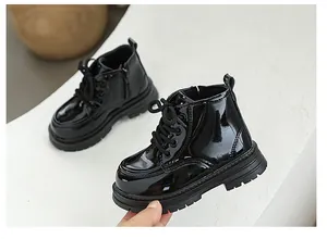 Close-up of shiny black patent leather children's Martin boots with side zip and soft sole