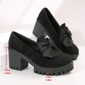 Close-up detail showing the 7.5cm chunky heel and 2.5cm platform on black bow shoes.