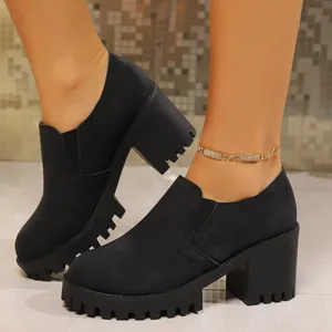 Stylish chunky black platform high heels with round toe and lug sole worn on model