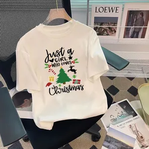 Vue détaillée de l'imprimé sapin de Noël festif sur un t-shirt blanc de qualité.