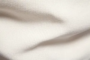 Close-up detail of white knitted fabric texture for men's casual winter sweater.
