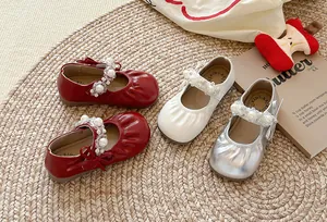 Vue détaillée des chaussures princesse à bride perlée pour filles en rouge et blanc.
