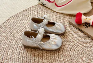 Vue détaillée de babies argentées pour filles avec plis et lanières ornées de perles.