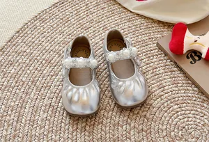 Détail de chaussures Mary Jane argentées pour filles avec perles et bout plissé élégant