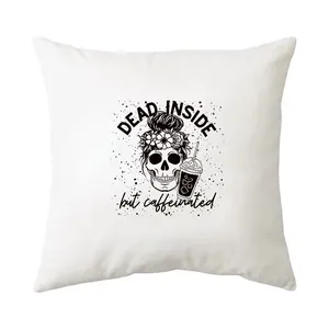 Vue détaillée du motif crâne 'Dead Inside But Caffeinated' sur un coussin blanc