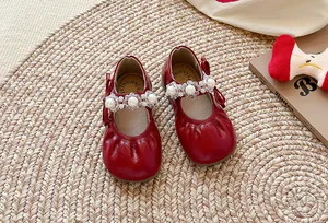 Détail de chaussures Mary Jane rouges pour enfants avec bride en perles et cristal