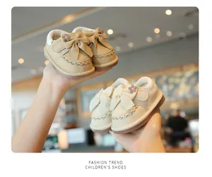 Dettaglio scarpe primi passi per neonati con fiocco e fiori decorativi in due colori.