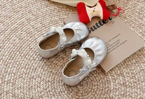 Gros plan de chaussures argentées pour filles avec perles et strass élégants