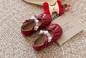 Détail de chaussures Mary Jane rouges pour filles avec perles et bout plissé.