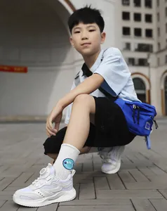 Junge trägt atmungsaktive weiße Mesh-Sportschuhe mit Drehverschluss in der Stadt