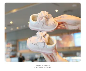 Dettaglio di scarpe primi passi rosa per bambina con fiocco decorativo