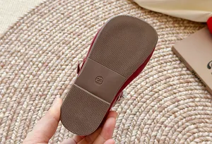Vue détaillée en gros plan de la semelle en caoutchouc d'une chaussure rouge à perles pour fille