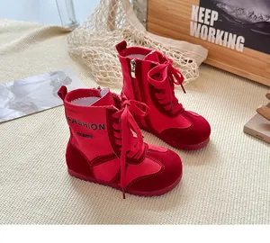 Detaillierte Seitenansicht roter Kinder-Martin-Boots mit 'FASHION' Stickerei an der Seite