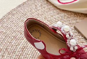 Détail macro de chaussures de princesse rouges pour filles avec perles et nœud