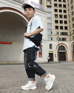 Weiße atmungsaktive Mesh-Sneaker für Jungen mit Drehverschluss in Outdoor-Umgebung