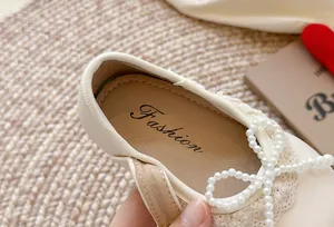 Gros plan de chaussures Mary Jane pour filles avec nœud en perles et dentelle