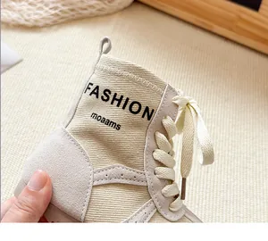 Nahaufnahme von beigen Kinder-Stiefeletten aus Wildleder und Canvas mit Aufdruck.