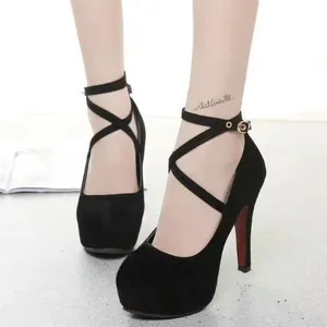 Detailed shot of elegant black platform high heels with a stylish cross strap at the ankle
