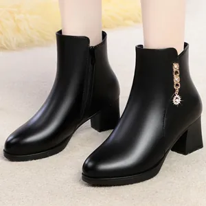 Vue détaillée de bottines en cuir noir avec talon bloc et décoration de breloque strass