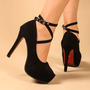 Detail view of black suede platform pumps with cross ankle straps and red soles.