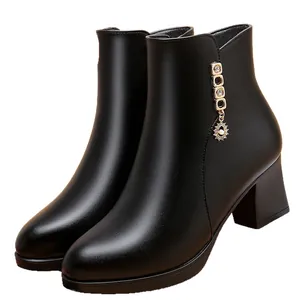 Bottines élégantes en cuir souple noir avec talon bloc et pendentif soleil doré
