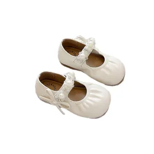 Élégantes chaussures de princesse crème pour filles avec bride en perles et bout plissé.