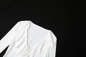 Gros plan d'une robe blanche à col en V avec volants élégants et laçage sur le devant