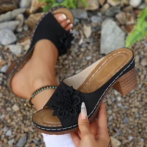 Nahaufnahme schwarzer Keilsandalen für Damen mit 3D-Blumendekor für den Sommer