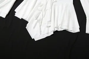 Détail rapproché des volants blancs et de l'ourlet irrégulier sur cette robe