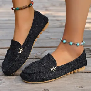 Detail of women's black tweed loafers featuring metal buckle and comfortable flat sole