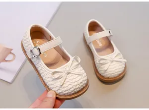 Dettaglio scarpe piatte bianche intrecciate da bambina con fiocco elegante