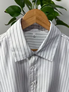 Detail view of the collar and vertical stripes on a white long-sleeve men's shirt