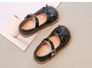 Vista dettagliata delle scarpe Mary Jane intrecciate nere per bambine con fiocco elegante