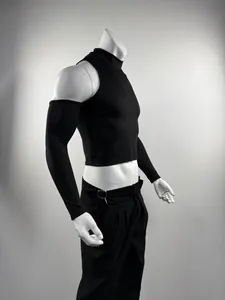 Detalle lateral de camiseta corta negra para hombre con cuello alto y hombros al aire.