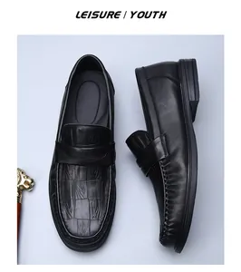 Detailed close-up view of men's black leather loafers with crocodile embossed pattern