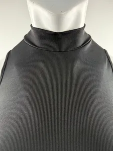 Primer plano de un top de punto acanalado negro de cuello alto en un maniquí de color blanco