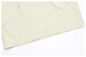 Gros plan sur la fermeture éclair et l'ourlet d'un coupe-vent de sport beige pour homme