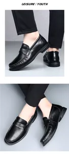 Close-up of premium black leather penny loafers for men worn by model in a studio setting