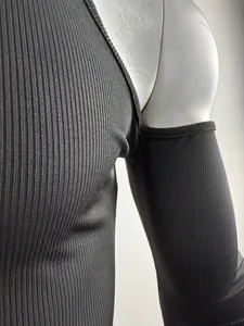 Primer plano de camiseta negra de canalé con manga larga y un moderno hombro descubierto.