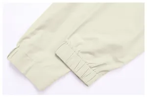 Détail rapproché des poignets élastiqués d'un coupe-vent de sport pour homme de couleur beige