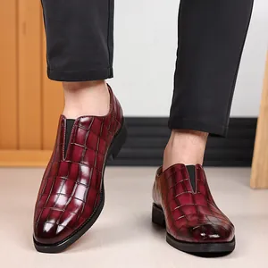 Detalle de zapatos de cuero color rojo oscuro para hombre con textura de piedra en relieve