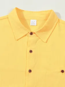 Detail of yellow linen shirt collar with size tag and buttons